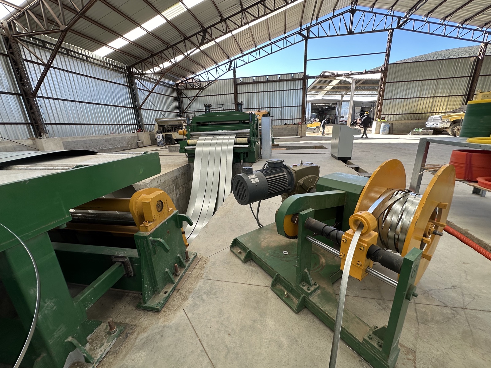 Steel coil being slit into strips on the slitting line