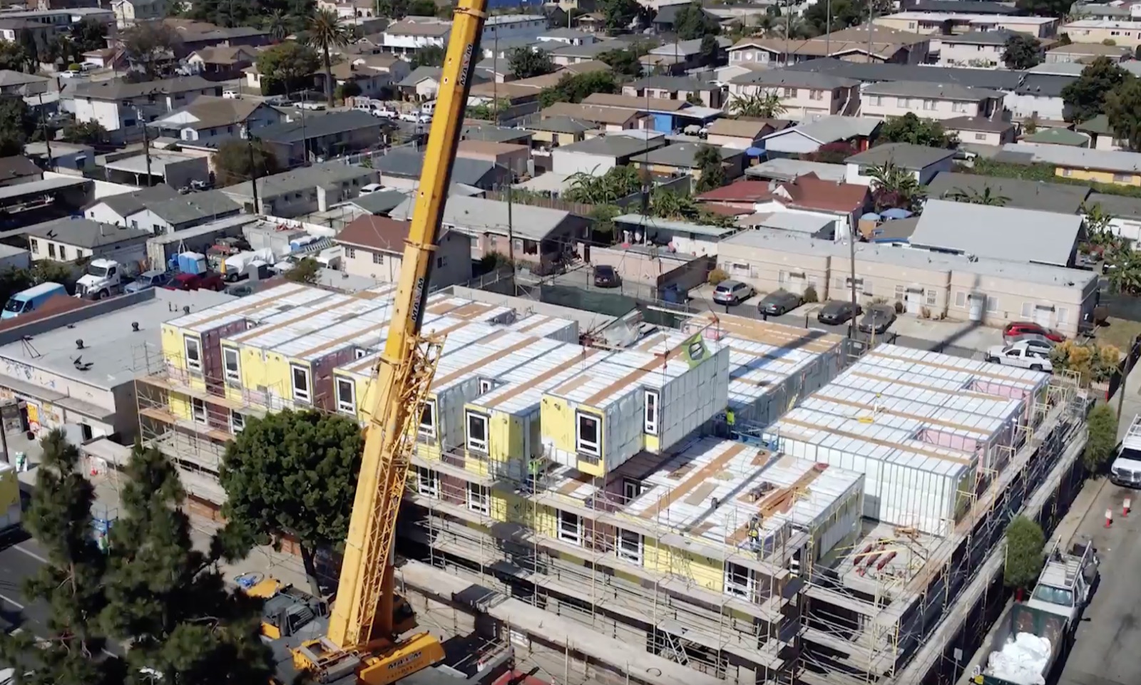 Crane setting volumetric modular units on a multifamily project, built in collaboration with ABS